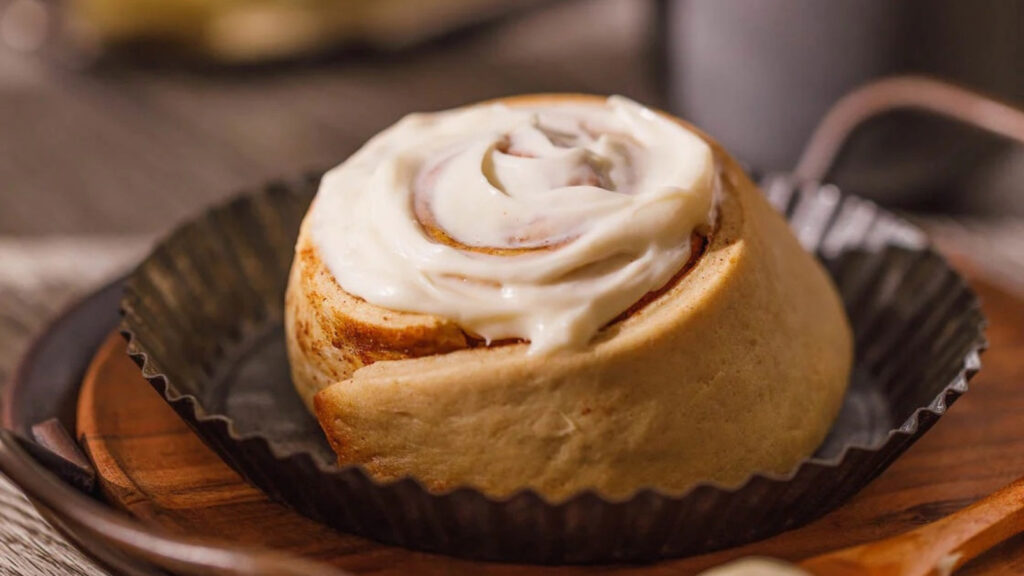 A single cinnamon roll in a tart pan.