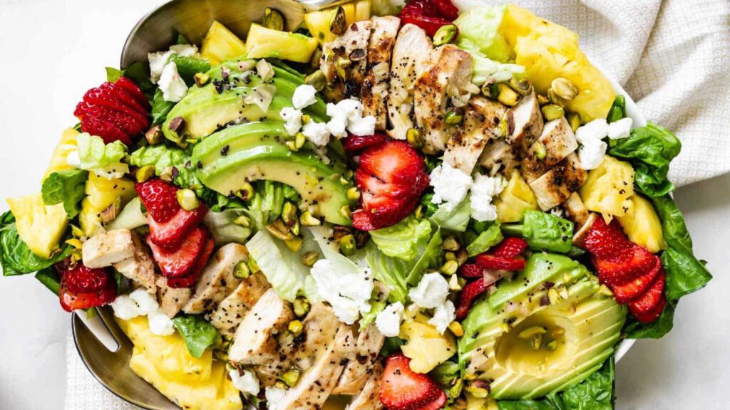 An overhead view of a white plate filled with strawberry chicken salad.