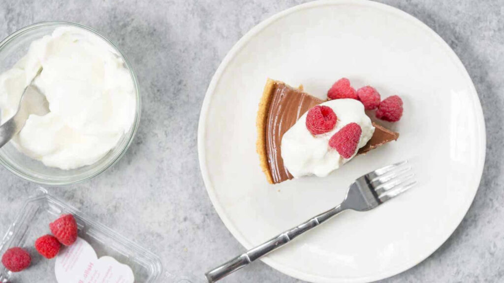 An overhead view of a slice of chocolate peanut butter pie on a white plate.