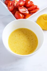 Asparagus Orzo dressing mixed and sitting in a white bowl.