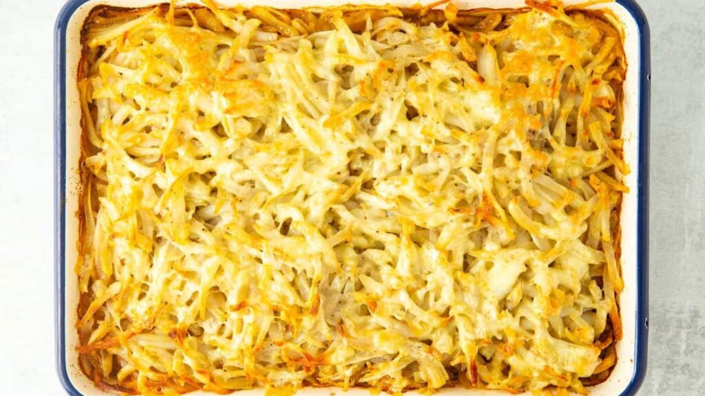 A casserole dish filled with baked cheesy hamburger hash brown casserole. Overhead focus.