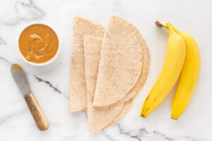 Banana Wrap recipe ingredients gathered on a white marble surface.