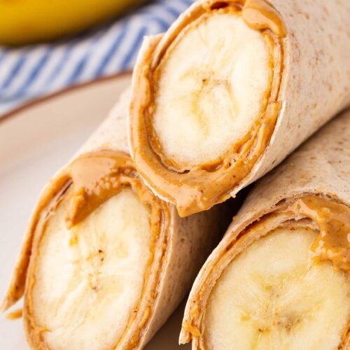 A closeup of three cut banana wrap halves on a plate.