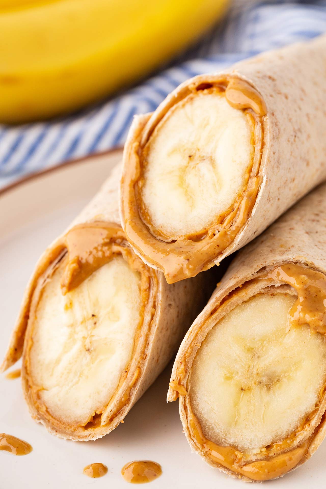 A closeup of three cut banana wrap halves on a plate.