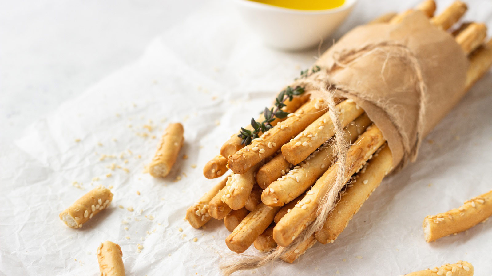 Italian grissini or salted bread sticks on a light stone background.