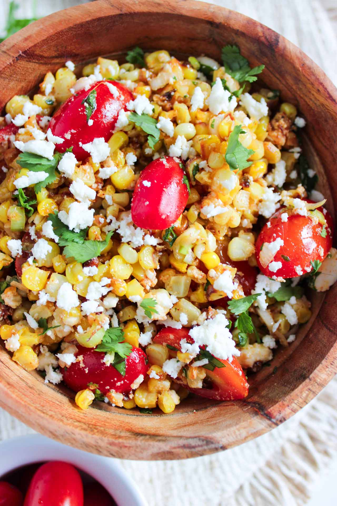 A wood bowl full of Roasted Corn Salad.