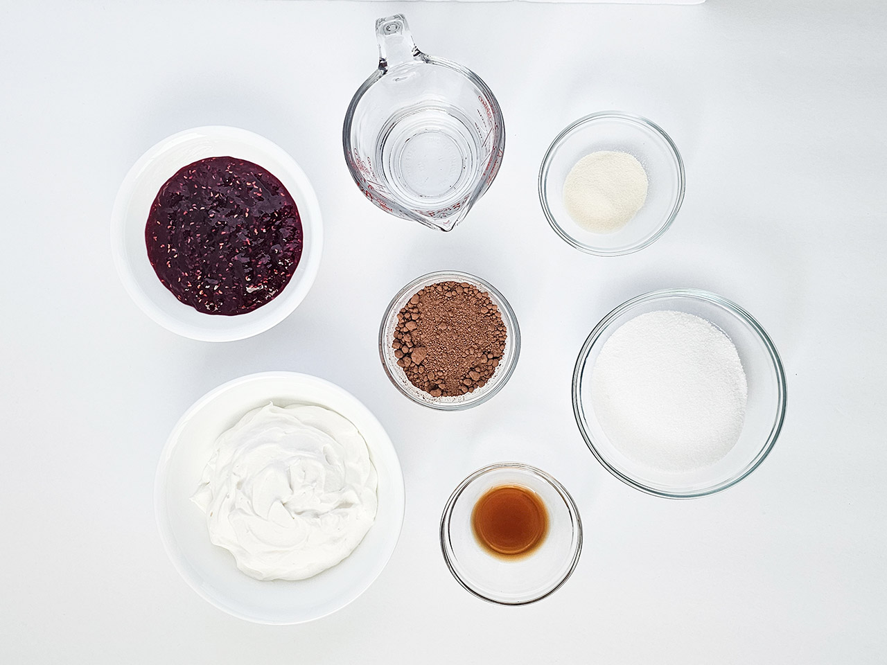 Raspberry chocolate mousse ingredients in individual glass bowls.