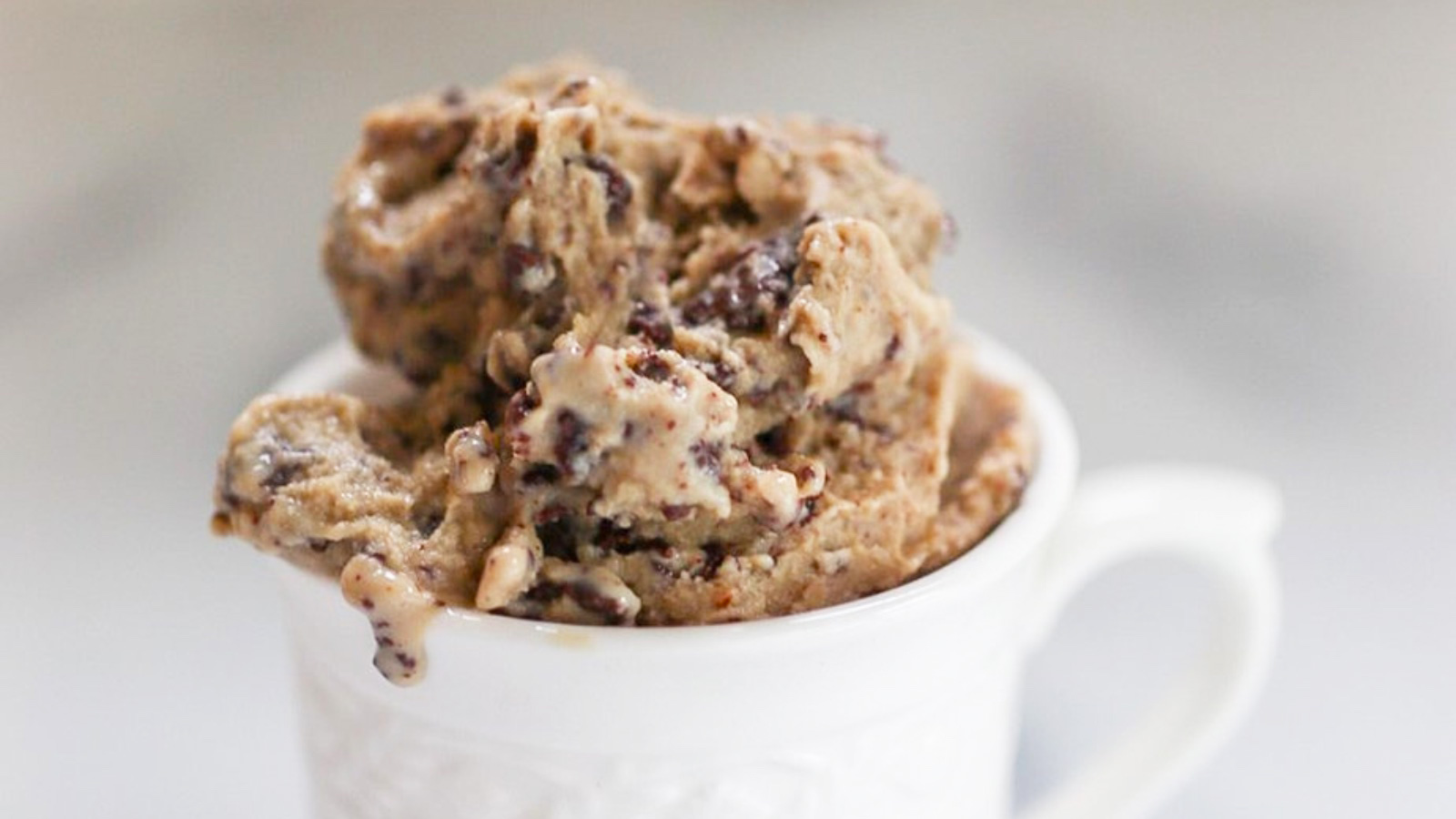A closeup of a white mug filled with dairy-free espresso ice cream with fudge swirl.