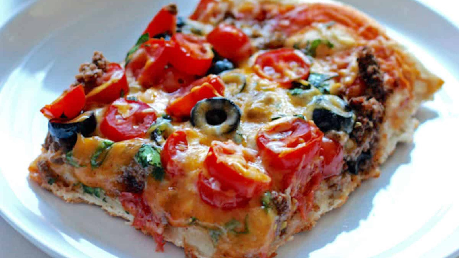 A slice of pizza on a white plate.