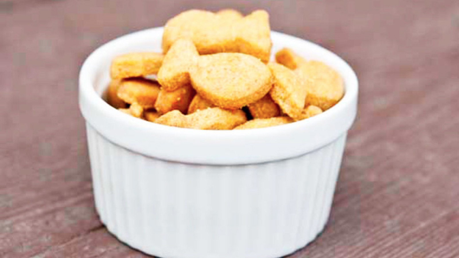 A white bowl filled with goldfish crackers.
