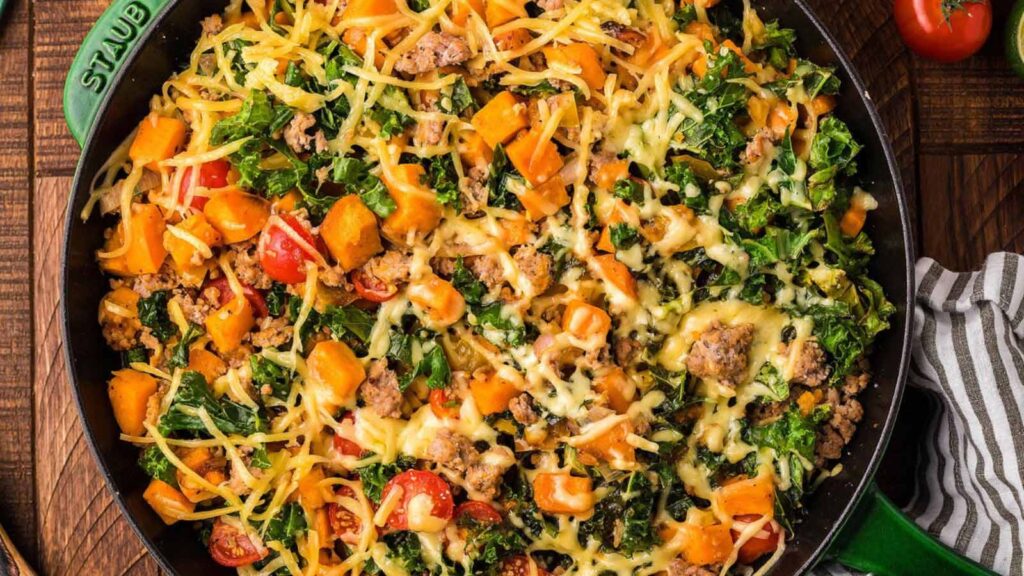A skillet filled with ground turkey sweet potato kale skillet. Overhead focus.