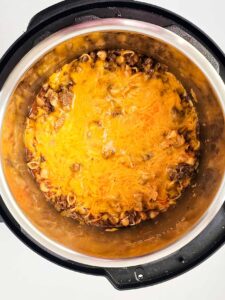Cheddar cheese melted over taco casserole in an Instant Pot.