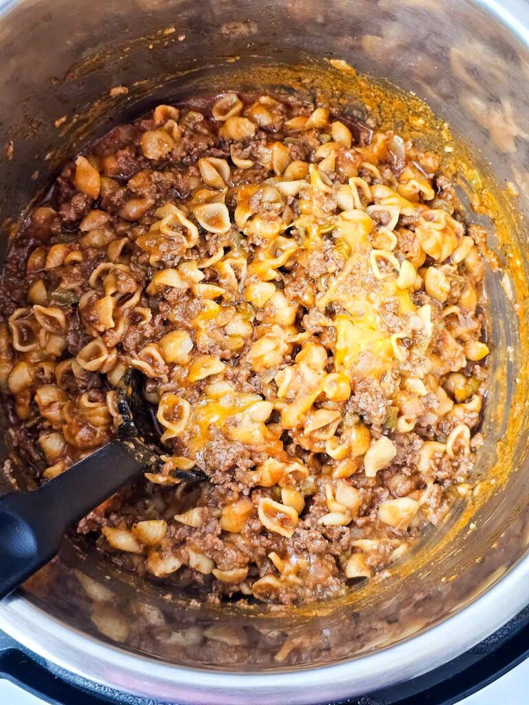 A spoon stirring the taco casserole in an Instant Pot.