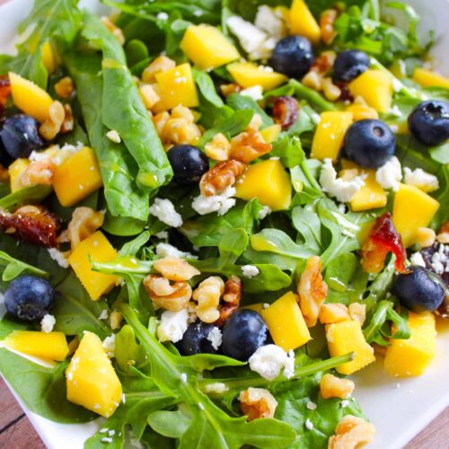 A white platter filled with Mango Blueberry Salad.