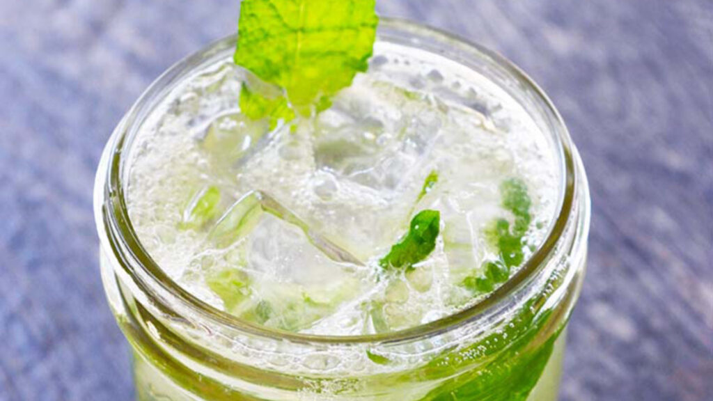 A mojito mocktail in a canning jar, garnished with fresh mint leaves.