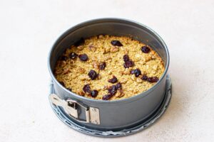 Walnuts and raisins pressed into the cake batter in a cake pan.
