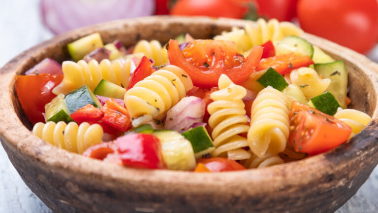 Bowl of fusili pasta salad with fresh vegetables.