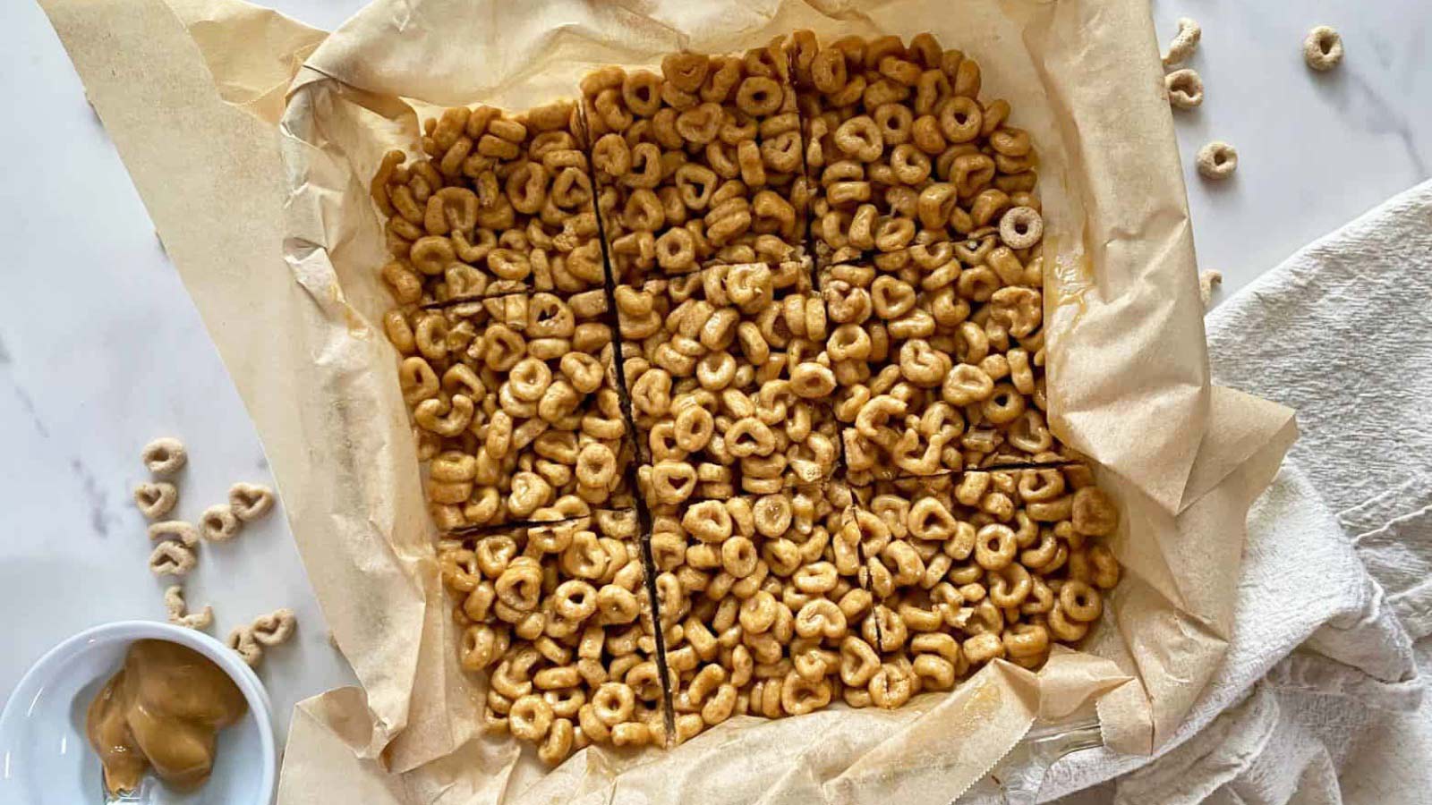 An overhead view of a batch of peanut butter cherries bars on a piece of parchment paper.