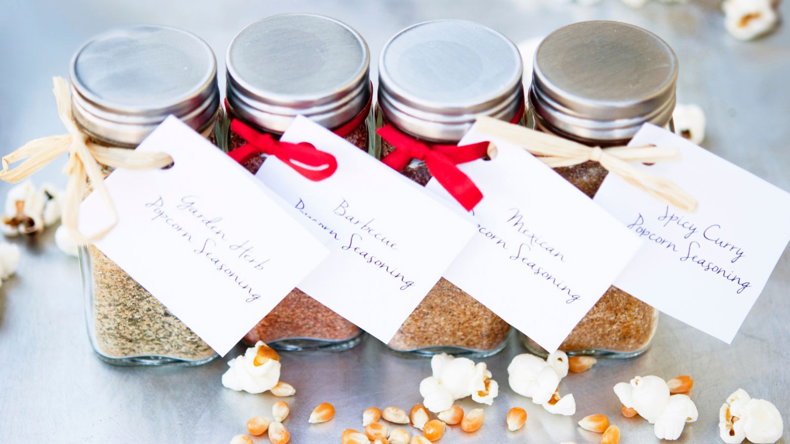 Homemade Popcorn Seasoning in four different jars with labels.
