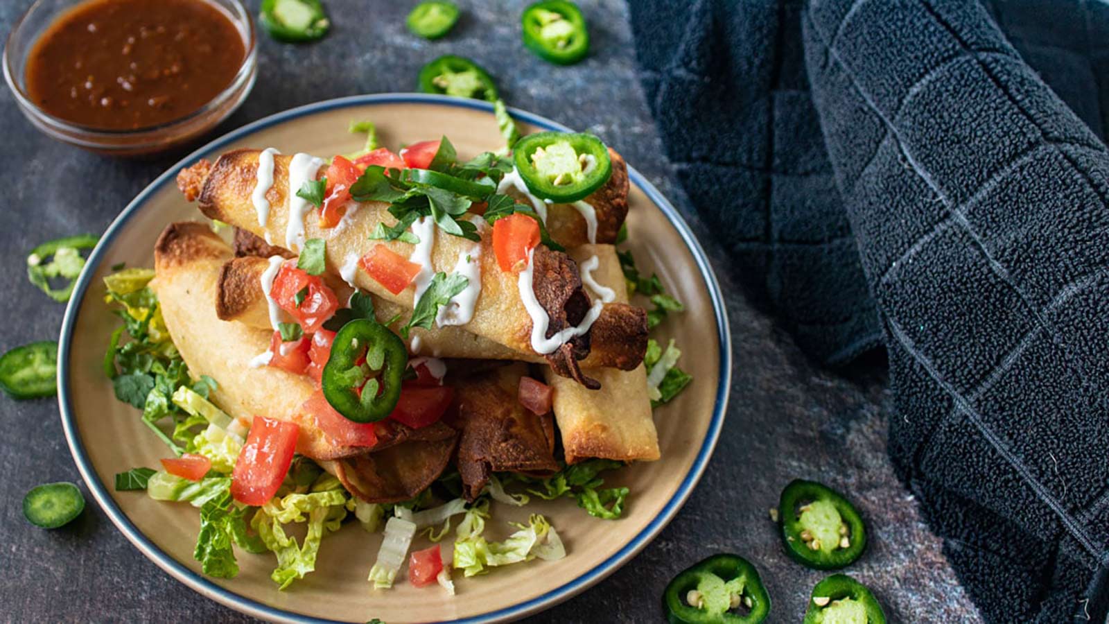 Pork taquitos on a place on a dark background.