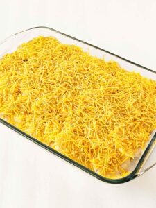 A second layer of cheese sprinkled over the top of the potatoes au gratin.