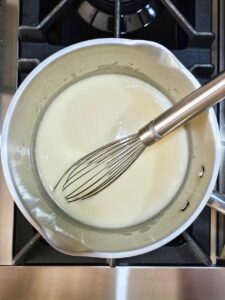 Milk added to butter in a pot.