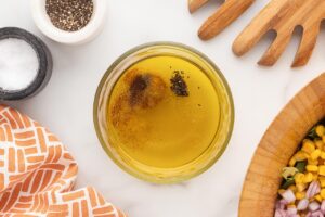 Dressing ingredients, unmixed, in a glass mixing bowl.