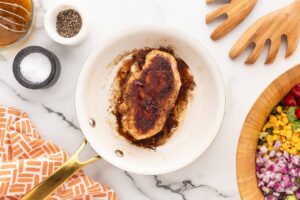 A cooked chicken breast in a skillet.