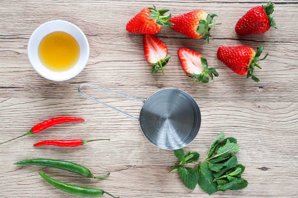 Spicy Strawberry Mocktail ingredients laying on a wood cutting board.