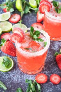 Angled view of two glasses of Strawberry Mojito Mocktail with fresh mint.