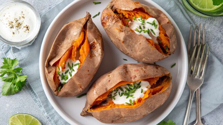 Stuffed baked sweet potatoes on a white plate. Top view.