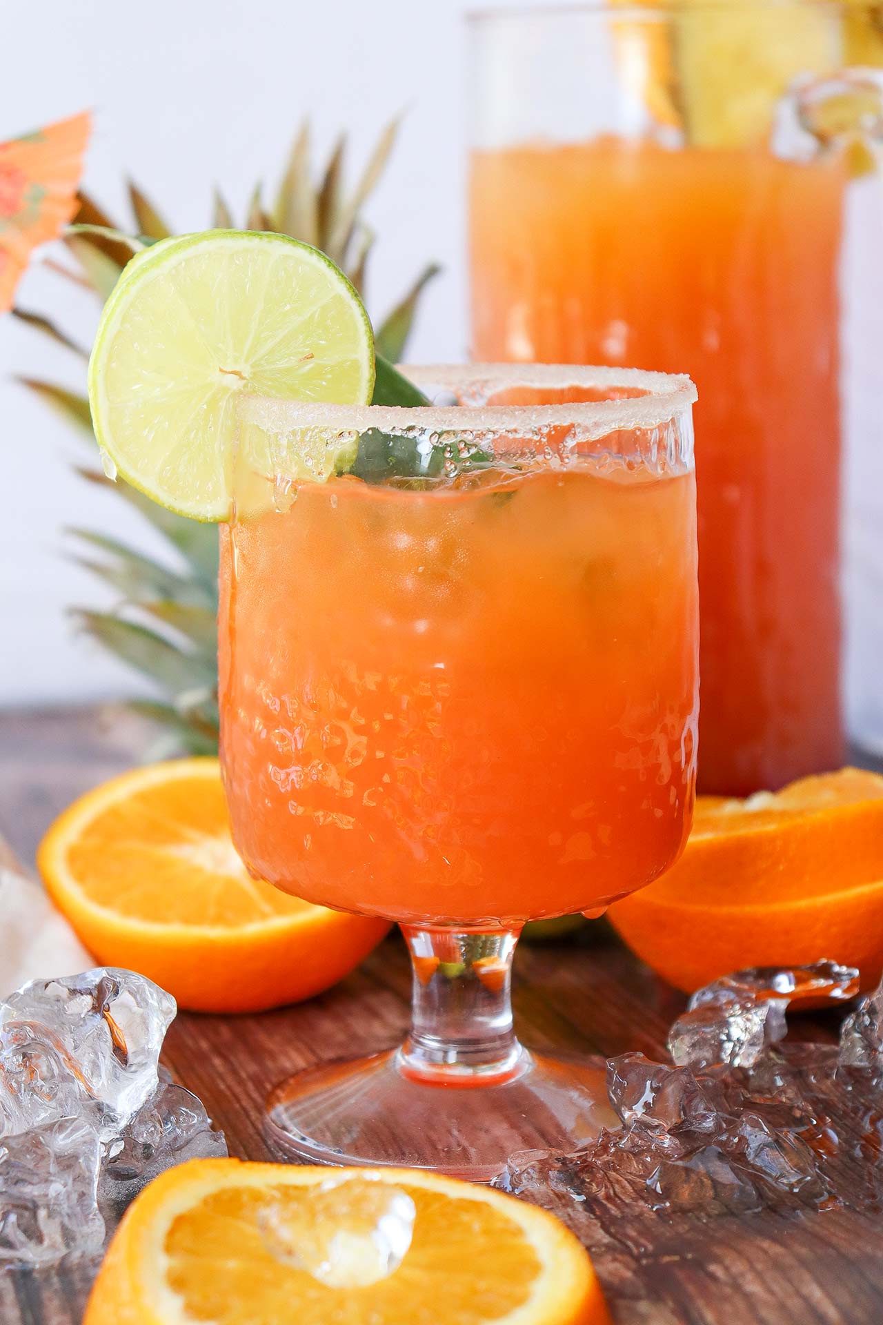 A glass of Tequila Sunrise Mocktail sitting on a wood table.