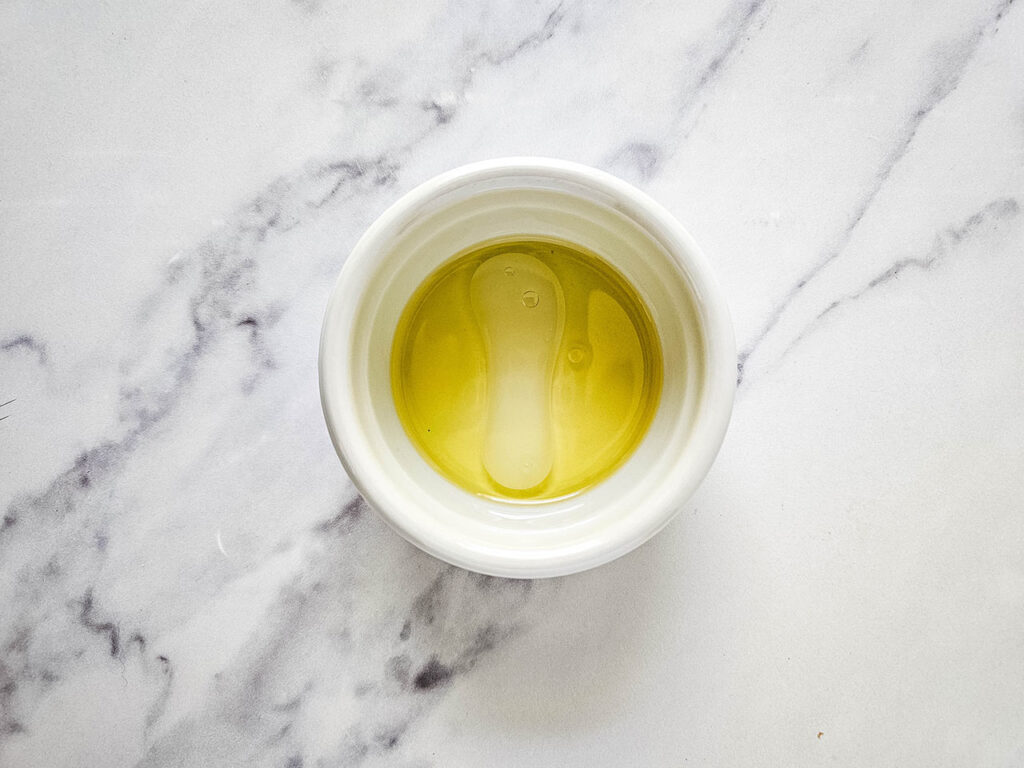 Oil, lime juice, and salt in a small, white bowl.