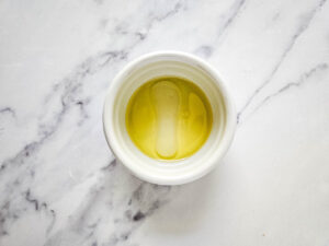 Oil, lime juice, and salt in a small, white bowl.