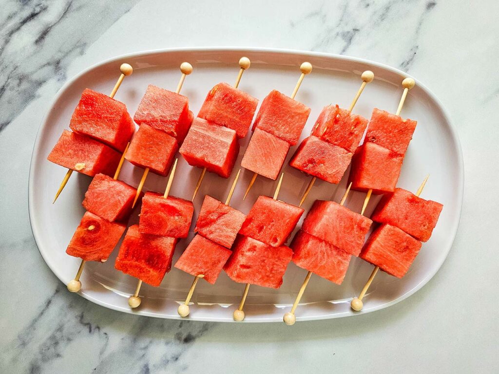 Ungarnished Watermelon Feta Skewers on a white, oval platter.