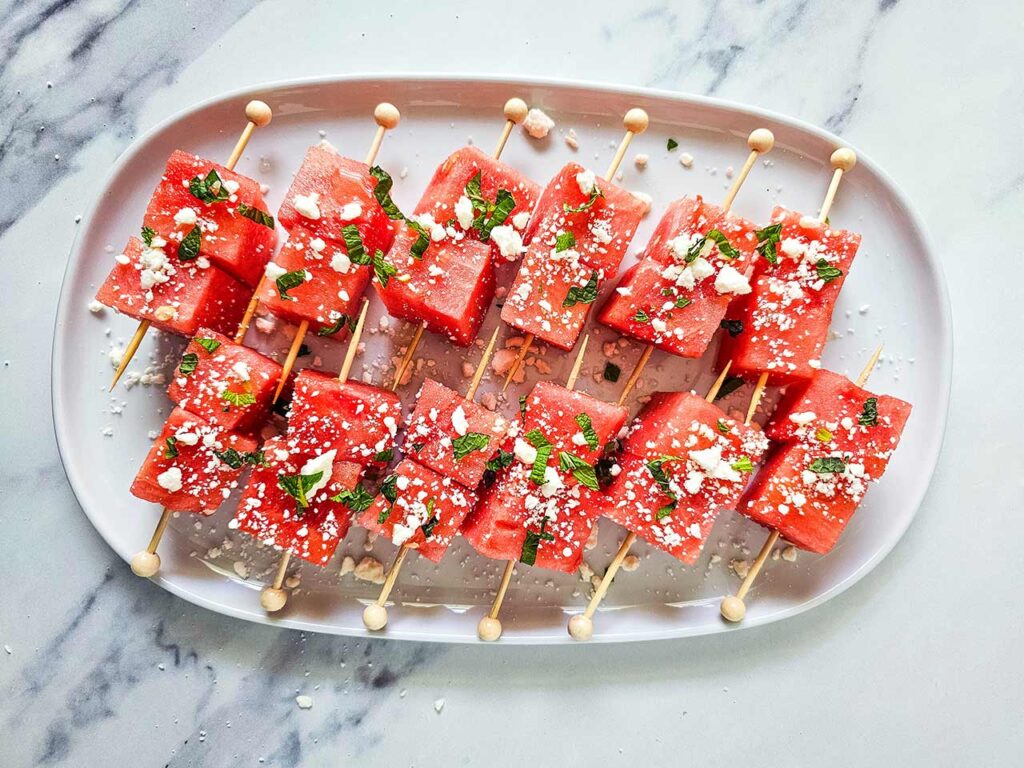 Watermelon Feta Skewers on a white platter.