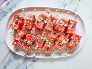 Watermelon Feta Skewers on a white platter.