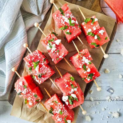 Watermelon Feta Skewers laying on a parchment lined cutting board.