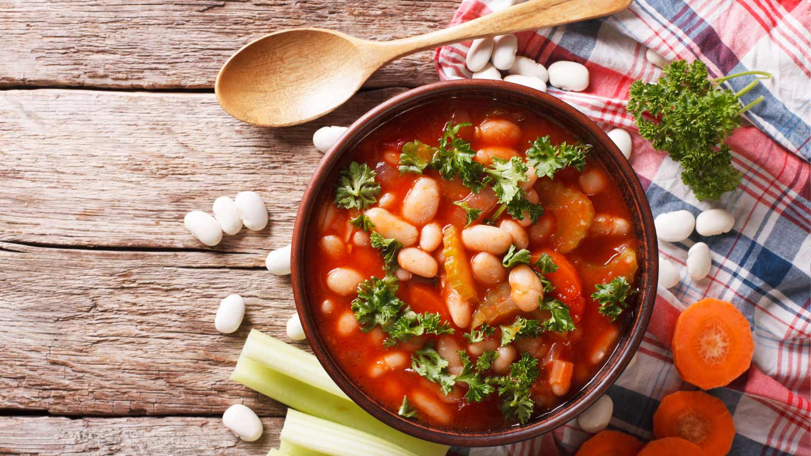 Homemade bean soup with ingredients. Horizontal view from above.