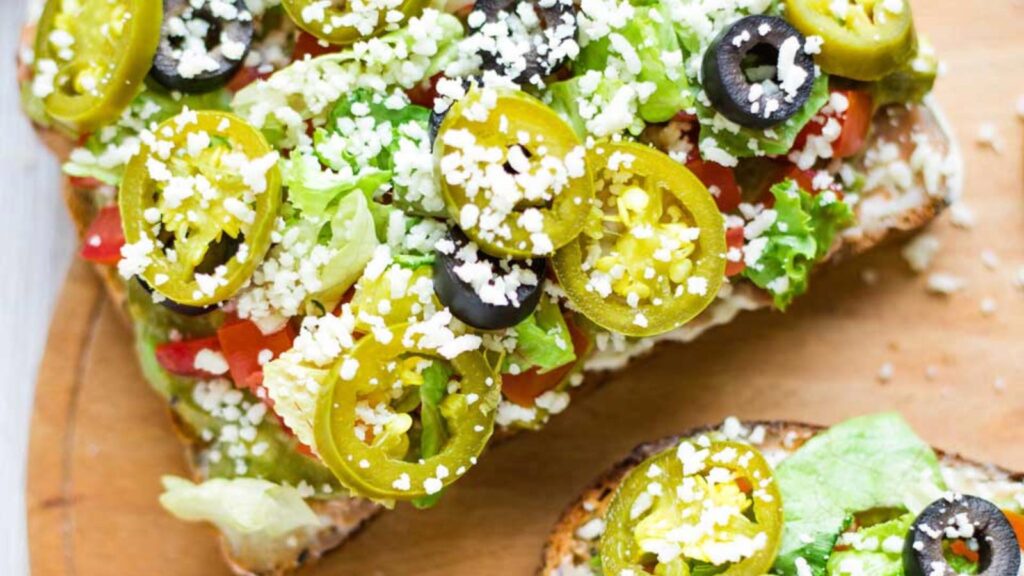 A closeup of two slices of Mexican avocado toast.