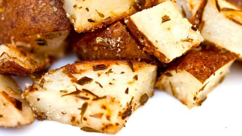 A closeup of country potatoes on a white surface.