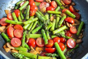 Vegetables cooking in a skillet.
