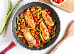 Chicken and veggies cooked and sitting in a skillet.