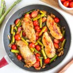 An overhead view of a skillet filled with a one-pan chicken dinner.