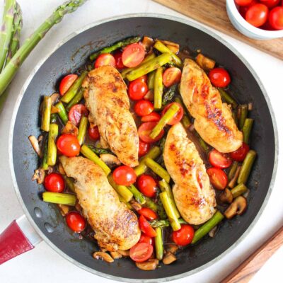 An overhead view of a skillet filled with a one-pan chicken dinner.