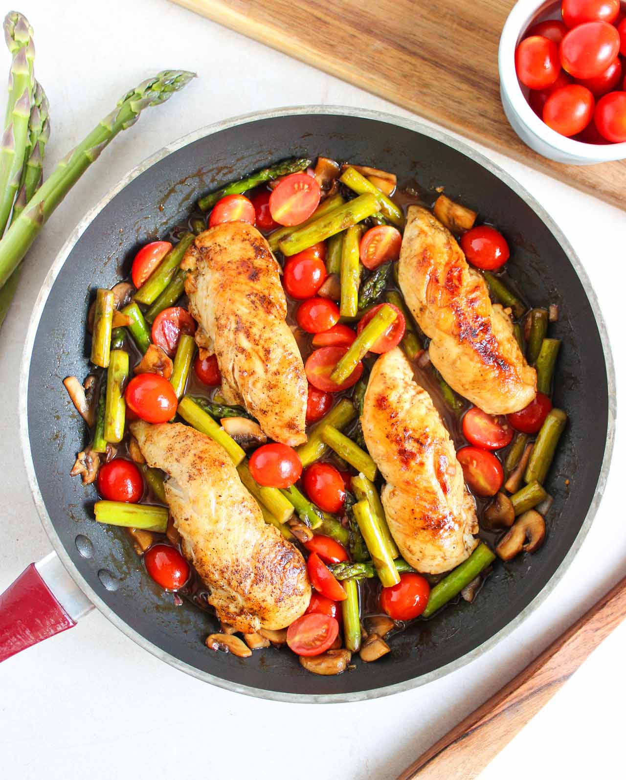 An overhead view of a skillet filled with a one-pan chicken dinner.