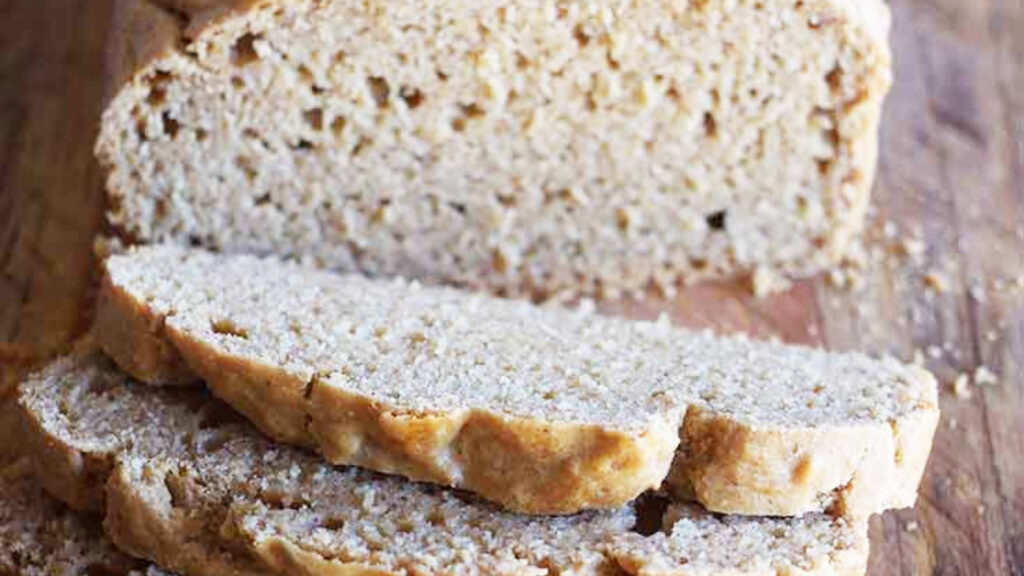 Slices of peanut butter bread cut from a loaf that sits behind them.
