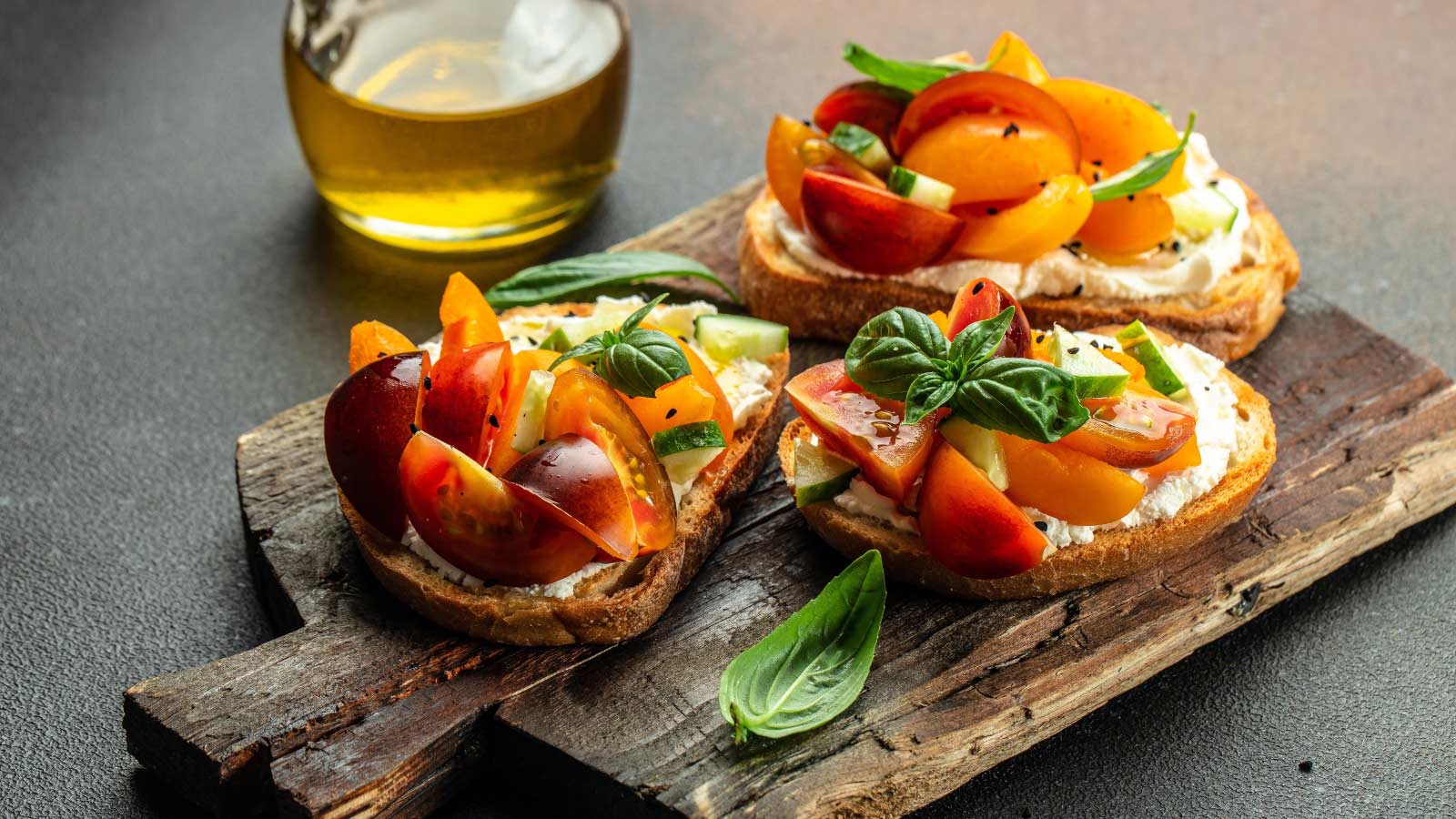 Bruschetta with cream cheese, peaches, tomatoes and green basil leaves,