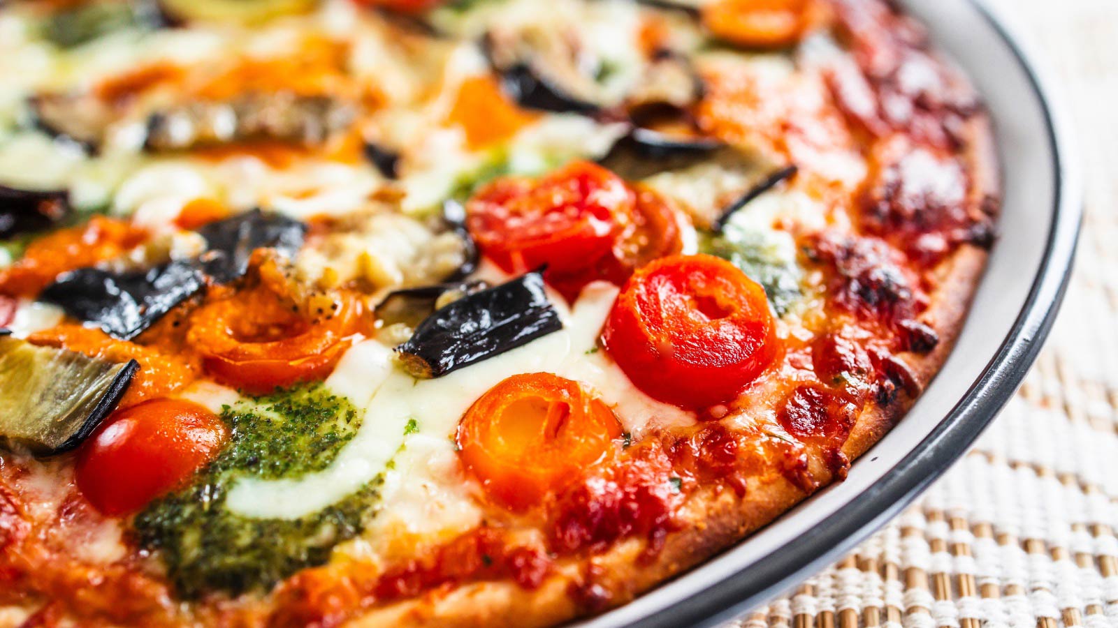 Closeup of a pizza on a pizza pan.