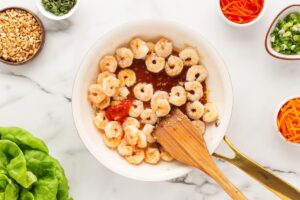 Sauce added to shrimp cooking in a skillet.